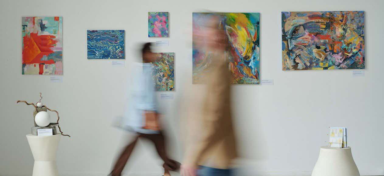Adults walking past an art exhibit